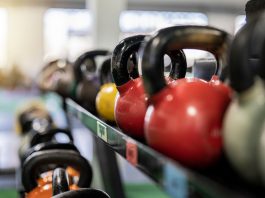 Close-up of colorful kettlebells on a rack in a modern gym indoors.