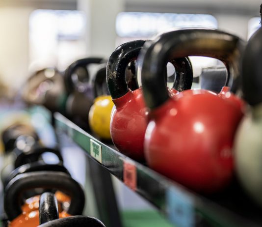 Close-up of colorful kettlebells on a rack in a modern gym indoors.