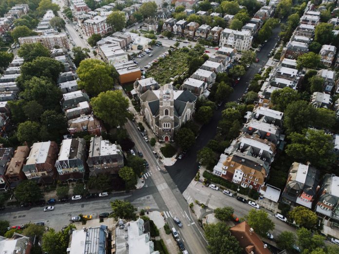 Drone shot capturing a scenic Philadelphia neighborhood with a prominent church at the center.