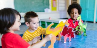 Three kids playing with dinosaur figures, fostering imagination and learning.