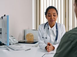 A female doctor consulting a patient in a modern medical office setting.