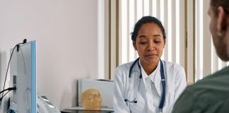 A female doctor consulting a patient in a modern medical office setting.