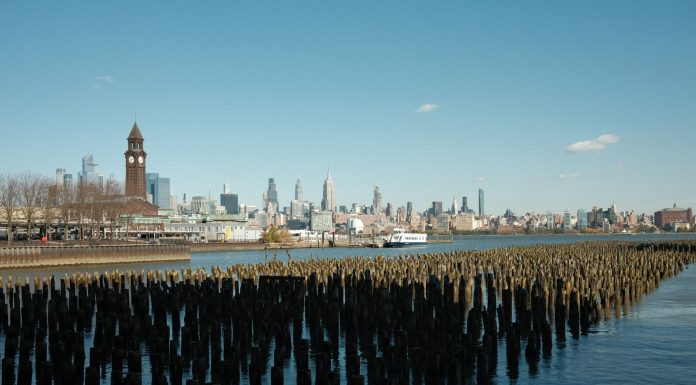 Scenic view of New York City skyline from Hoboken waterfront with wooden piers in the foreground.