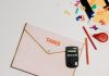 Flat lay of a tax preparation workspace with calculator, envelope, and colorful numbers.