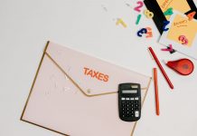 N.J. Schools Chief Vows to Modernize Funding Formula Flat lay of a tax preparation workspace with calculator, envelope, and colorful numbers.