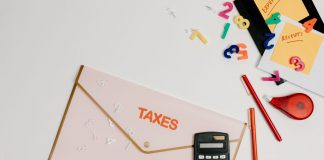 Flat lay of a tax preparation workspace with calculator, envelope, and colorful numbers.