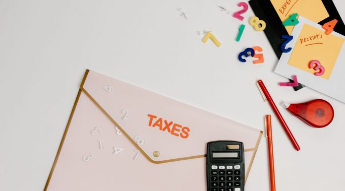 N.J. Schools Chief Vows to Modernize Funding Formula Flat lay of a tax preparation workspace with calculator, envelope, and colorful numbers.