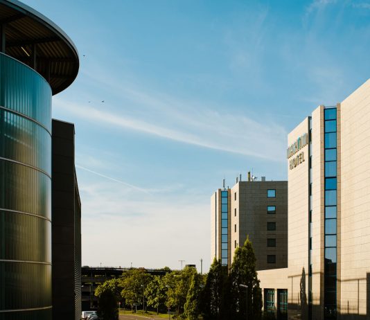 Contemporary hotel architecture with blue sky backdrop in city environment.