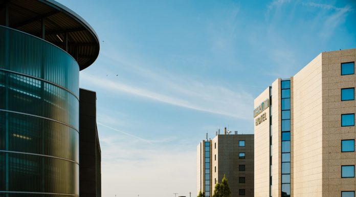 New Date Set for Heights Hospital Public Hearing Contemporary hotel architecture with blue sky backdrop in city environment.