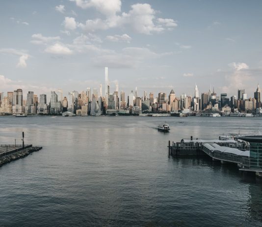 Qué Hacer en West New York Este Fin de Semana: 10 Planes Imperdibles en 2026 Panoramic view of New York City skyline from waterfront with a tranquil river foreground.