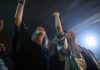 Vibrant party scene with diverse friends dancing and raising hands at a club.