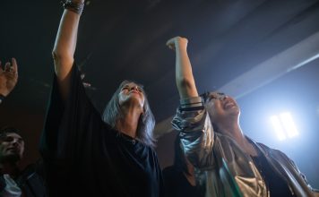 Queer Comedy at Art House: A Warm, Winning Night in Jersey City Vibrant party scene with diverse friends dancing and raising hands at a club.