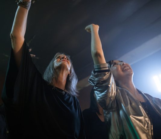 Vibrant party scene with diverse friends dancing and raising hands at a club.