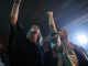 Vibrant party scene with diverse friends dancing and raising hands at a club.