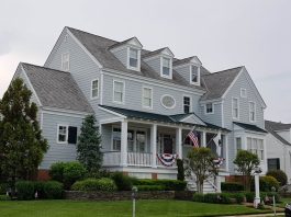 Elegant colonial-style house in Cape May, NJ with manicured lawn and American flags.