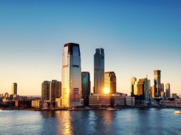Breathtaking sunrise view over New York City skyline with reflection on the water.