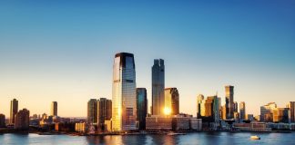 Breathtaking sunrise view over New York City skyline with reflection on the water.
