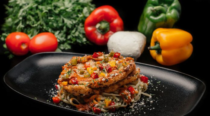 River Street Garage Launches $10 Chicken Parm Dinner Deal for Hoboken Readers Savor a mouthwatering dish of chicken pasta garnished with fresh vegetables on a stylish black plate.
