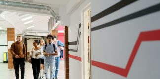A diverse group of teenagers walking together in a modern school hallway.