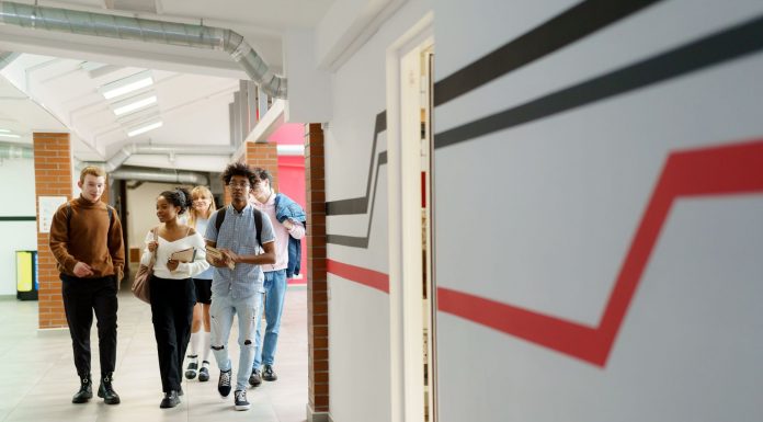 A diverse group of teenagers walking together in a modern school hallway.