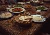 The Canteen: A South Asian Supper Club in Jersey City A vibrant spread of Indian dishes on a colorful tablecloth, perfect for culinary themes.