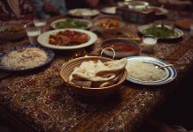 The Canteen: A South Asian Supper Club in Jersey City A vibrant spread of Indian dishes on a colorful tablecloth, perfect for culinary themes.