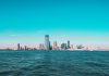 10 Things Locals Love About Living in Jersey City (2026 Guide) Panoramic view of Manhattan skyline with modern skyscrapers under a clear blue sky.