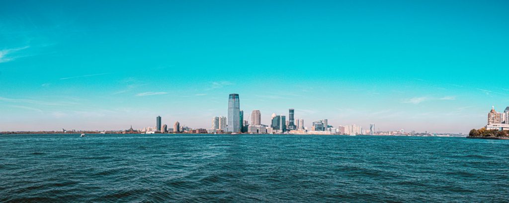 Panoramic view of Manhattan skyline with modern skyscrapers under a clear blue sky.