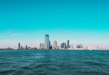 10 Things Locals Love About Living in Jersey City (2026 Guide) Panoramic view of Manhattan skyline with modern skyscrapers under a clear blue sky.
