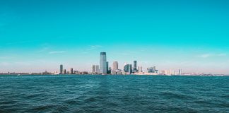 Panoramic view of Manhattan skyline with modern skyscrapers under a clear blue sky.