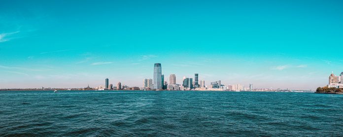Panoramic view of Manhattan skyline with modern skyscrapers under a clear blue sky.