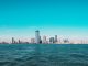 Panoramic view of Manhattan skyline with modern skyscrapers under a clear blue sky.