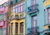 Vibrant city scene with colorful apartment facades of pink, yellow, and blue.
