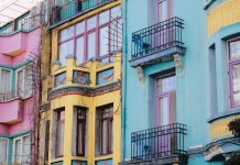 Vibrant city scene with colorful apartment facades of pink, yellow, and blue.