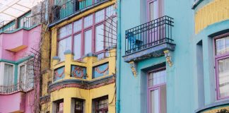 Two Jersey City Councilmen Push for Greater Tenant Protections in Tax-Abated Buildings Vibrant city scene with colorful apartment facades of pink, yellow, and blue.