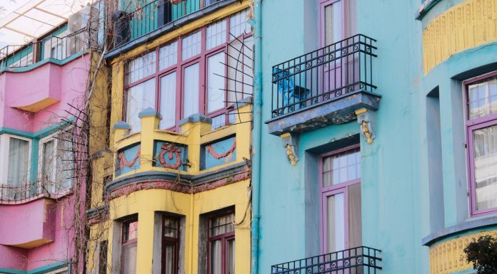 Vibrant city scene with colorful apartment facades of pink, yellow, and blue.