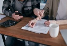Utility Relief Program Offers $200 Help for Eligible Hudson County Families A couple analyzing financial documents and using a calculator at a home table.