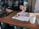 A couple analyzing financial documents and using a calculator at a home table.