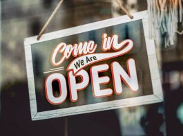 Washington Street’s New Wave: 13 Spots Opening in Hoboken A welcoming 'Come in, We Are Open' sign hanging on a glass window of an urban shop.