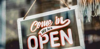 Washington Street’s New Wave: 13 Spots Opening in Hoboken A welcoming 'Come in, We Are Open' sign hanging on a glass window of an urban shop.