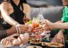 Group of friends clinking glasses with cocktails at an outdoor terrace party in Dubai.