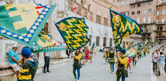 Your Guide to the Best Local Events This Weekend Vibrant street parade with flags and performers in historic square, capturing the lively festival atmosphere.