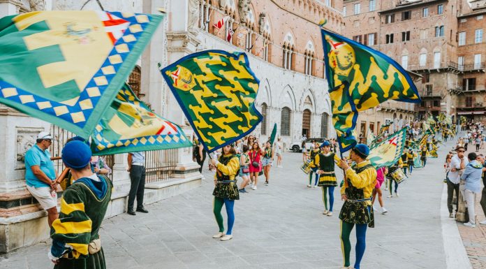 Your Guide to the Best Local Events This Weekend Vibrant street parade with flags and performers in historic square, capturing the lively festival atmosphere.