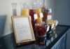 A sophisticated bubbly bar arrangement featuring juices, fresh raspberries, and an inviting sign.