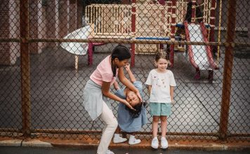 Actividades para Niños en Hoboken: Guía Completa 2026 para Familias Children having fun at a playground, playing around a fence, enjoying summer day.