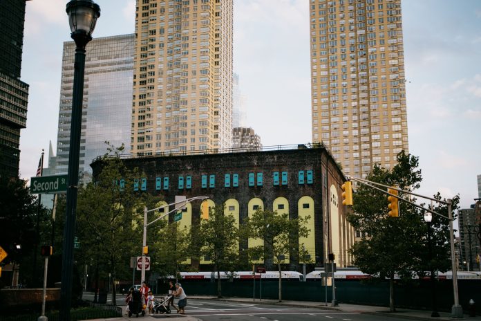 average-rent-hoboken-2026-guide A vibrant intersection in Jersey City with towering skyscrapers and a historic building.