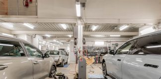 Interior of an automotive repair shop with cars undergoing maintenance and servicing.