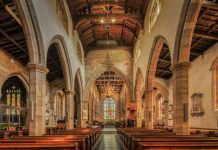 A beautifully detailed view of the nave inside a historic English church, showcasing gothic architecture.