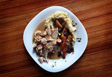 Best Dominican Restaurants in North Bergen, NJ (2026 Guide) A savory dish of meat and vegetables with mashed potatoes on a wooden table.