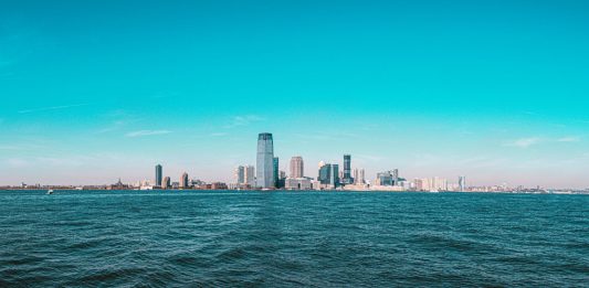 Best Things To Do in Jersey City This Weekend: Your 2026 Guide Panoramic view of Manhattan skyline with modern skyscrapers under a clear blue sky.